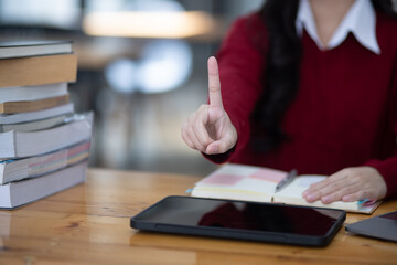 Happy young asian woman doing hands touch at desk in office, Female student with stack of books and laptop.