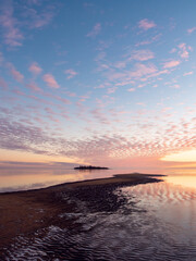 Colorful sunset on the beach with fluffy clouds in the pastel colored sky, Bothnian Bay, Baltic Sea, Finland