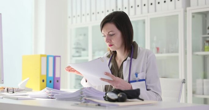 Woman doctor examining patient examination paper documents 4k movie slow motion. Paperwork in medicine concept