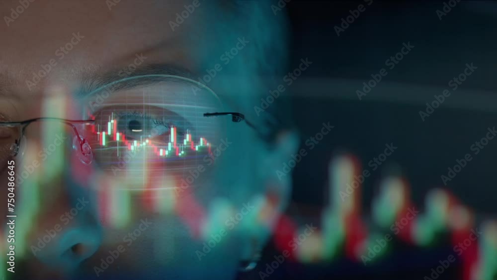 Poster trader wearing glasses is working on laptop computer. screen with stock market charts and bitcoin bt