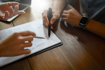 Close up of client hand signing health insurance contract with agent