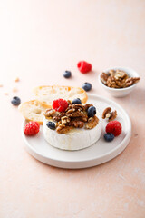 Baked camembert cheese with nuts and berries