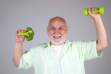 Healthy fit Senior. Healthy food for fit aged people. Power old mature man. Grandfather hold dumbbell and broccoli. Healthy old aged senior, studio. Healthy diet. Aged Dieting. Powerful health senior.
