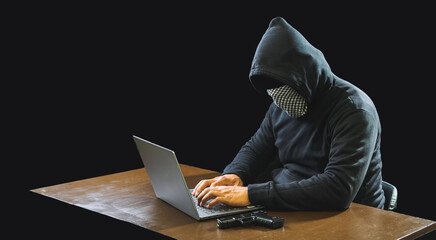 Hand hacker spy man one person in black hoodie sitting on table looking computer laptop used login password attack security to data digital internet network system night dark background copy space
