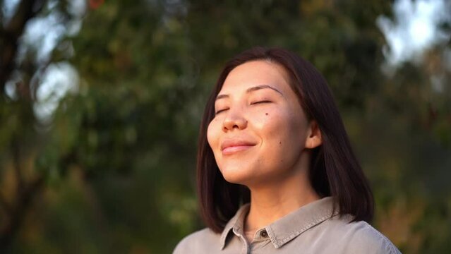 Asian young woman with healthy skin watching the sunset outdoors in summer