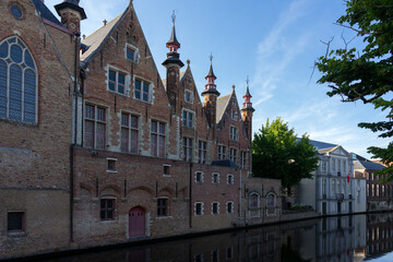Historic buildings reflected on the canal in the old town of the beautiful city of Brugge in Belgium.