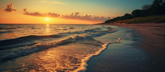 Sunset over a Peaceful beach with waves gently breaking on the shore and warm colors reflecting on the water.