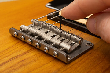 Luthier set the action on electric guitar using an allen key