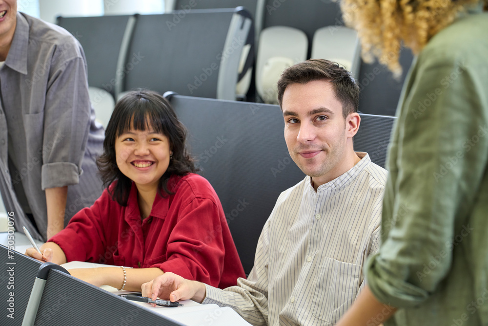Poster group of multinational students having a conversation in the classroom