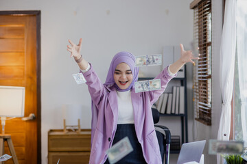 Fototapeta na wymiar Young asian islamic women throwing up money at office desk, Businesswoman throwing money in the air.