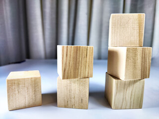 Small wooden cubes in columns, lined up in row. The concept of progressive movement in achieving the goal. Steps and stages of project development and implementation