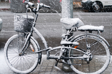 Fototapeta na wymiar Snowy Barcelona: Bicycle Parked on Snow-Covered City Street