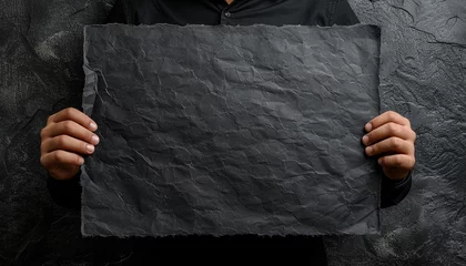 Papier Peint photo autocollant Vielles portes hand holding old black paper with black wall background