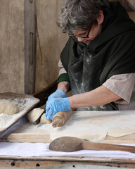 Woman hands rolling out dough in knight camp at the festival of historical reconstruction