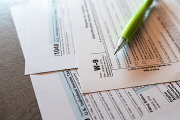 US federal income tax return form 1040 w 9 W-9 ballpoint pen on office desk - obrazy, fototapety, plakaty