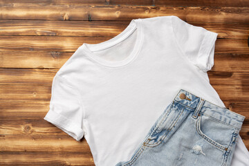 White T-shirt and jeans on brown wooden background