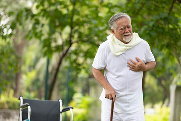 asian senior man suffering and having chest pain from heart attack in the park