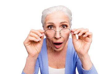 Discounts and sales? What a great news! Close up portrait of old woman looks over her spectacles in...