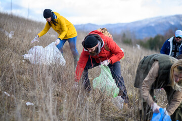 Group of activists picking up litter in nature, environmental pollution, eco activism. and plogging...
