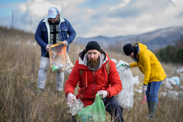 Group of activists picking up litter in nature, environmental pollution, eco activism. and plogging...