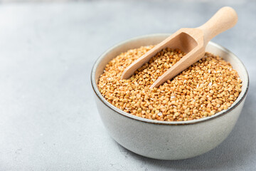 Green buckwheat in a bowl on a wooden kitchen table.Superfood.Raw buckwheat porridge.Healthy vegan food concept, eco products, diet. Copy space.Organic food.weight loss and proper nutrition.