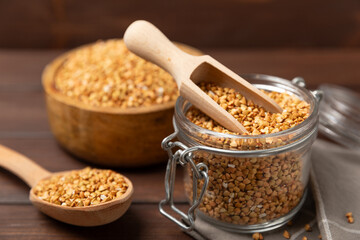 Green buckwheat in a bowl on a wooden kitchen table.Superfood.Raw buckwheat porridge.Healthy vegan food concept, eco products, diet. Copy space.Organic food.weight loss and proper nutrition.