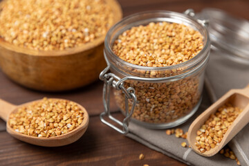Green buckwheat in a bowl on a wooden kitchen table.Superfood.Raw buckwheat porridge.Healthy vegan food concept, eco products, diet. Copy space.Organic food.weight loss and proper nutrition.