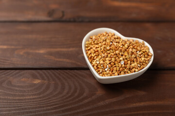 Green buckwheat in a bowl on a wooden kitchen table.Superfood.Raw buckwheat porridge.Healthy vegan food concept, eco products, diet. Copy space.Organic food.weight loss and proper nutrition.
