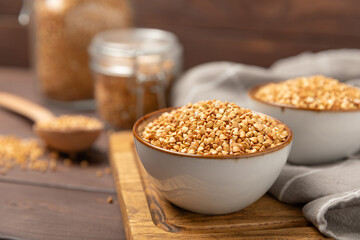 Green buckwheat in a bowl on a wooden kitchen table.Superfood.Raw buckwheat porridge.Healthy vegan food concept, eco products, diet. Copy space.Organic food.weight loss and proper nutrition.