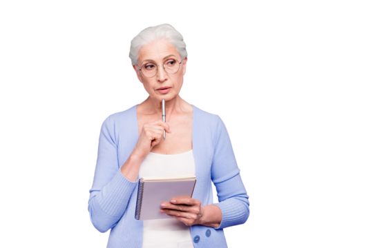 Gray haired old serious business woman wearing glasses, thinking about plans strategy future, holding paper note book with pen. Isolated over violet purple background