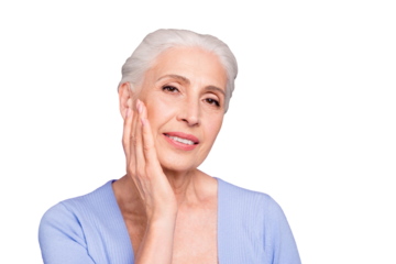 Portrait of gray haired beautiful smiling old lady applying cream gel lotion on her face, copy space, isolated over violet background