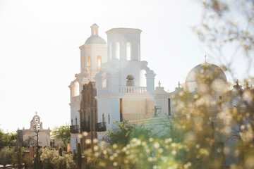 Built in 1797, afternoon light shines on the historic Spanish colonial era San Xavier del Bac Mission in Tucson, Arizona, USA. - obrazy, fototapety, plakaty