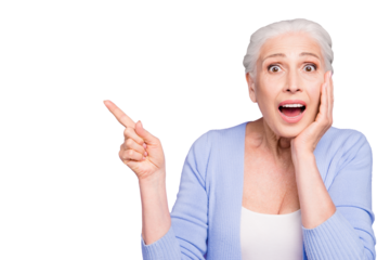 Portrait of gray haired old beautiful cheerful shocked woman with opened mouth, pointing with finger, palm to cheek. Empty blank copy space. Isolated over violet purple background