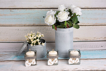 Decoración con florero con rosas blancas y velas.