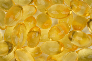 Gelatinous capsules filled with cod liver oil and omega 3 concept background