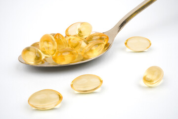 Spoon full of cod liver oil supplement capsules concept background