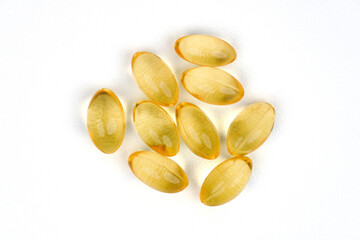 Golden color oil supplements isolated on white background