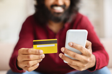 Cropped of bearded man with smartphone and credit card