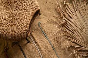 Old vintage wicker chair and palm leaves on the sand. Top view