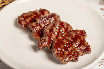 Freshly grilled beef tenderloin slices. Slices of cooked tenderloin on wood background. high quality photo. Close up
