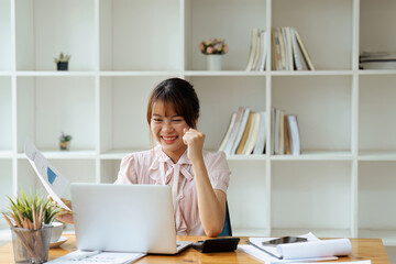 accountant working on desk using calculator for calculate finance report in office