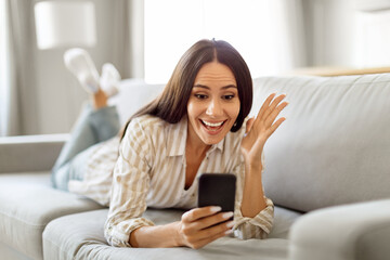 Good News. Overjoyed Female Looking At Smartphone Screen And Exclaiming With Excitement