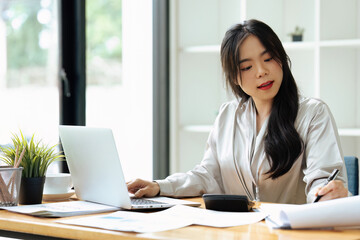 accountant working on desk using calculator for calculate finance report in office