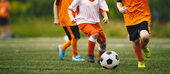 Obraz premium Young Soccer Players Chasing Soccer Ball in a Duel. Kids Play Sports Tournament Match. Two Players Compete For Soccer Ball