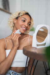 Vertical banner with Skin care concept. african american smiling woman using gua sha scraper for...
