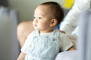 Portrait of enjoy happy love family asian mother playing with adorable little asian baby newborn infant, Mom touching care with cute son in a white bedroom.Love of family concept