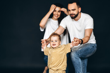 A Man and a Woman Holding a Childs Hands