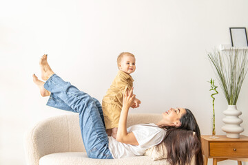 Woman Sitting on Top of a Couch Holding a Baby