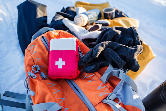 A first aid kit is on a backpack with things, hiking equipment for hiking, survival in the forest.