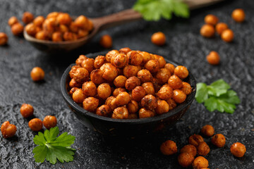 Roasted spicy chickpeas in rustic wooden bowl. Healthy snack.